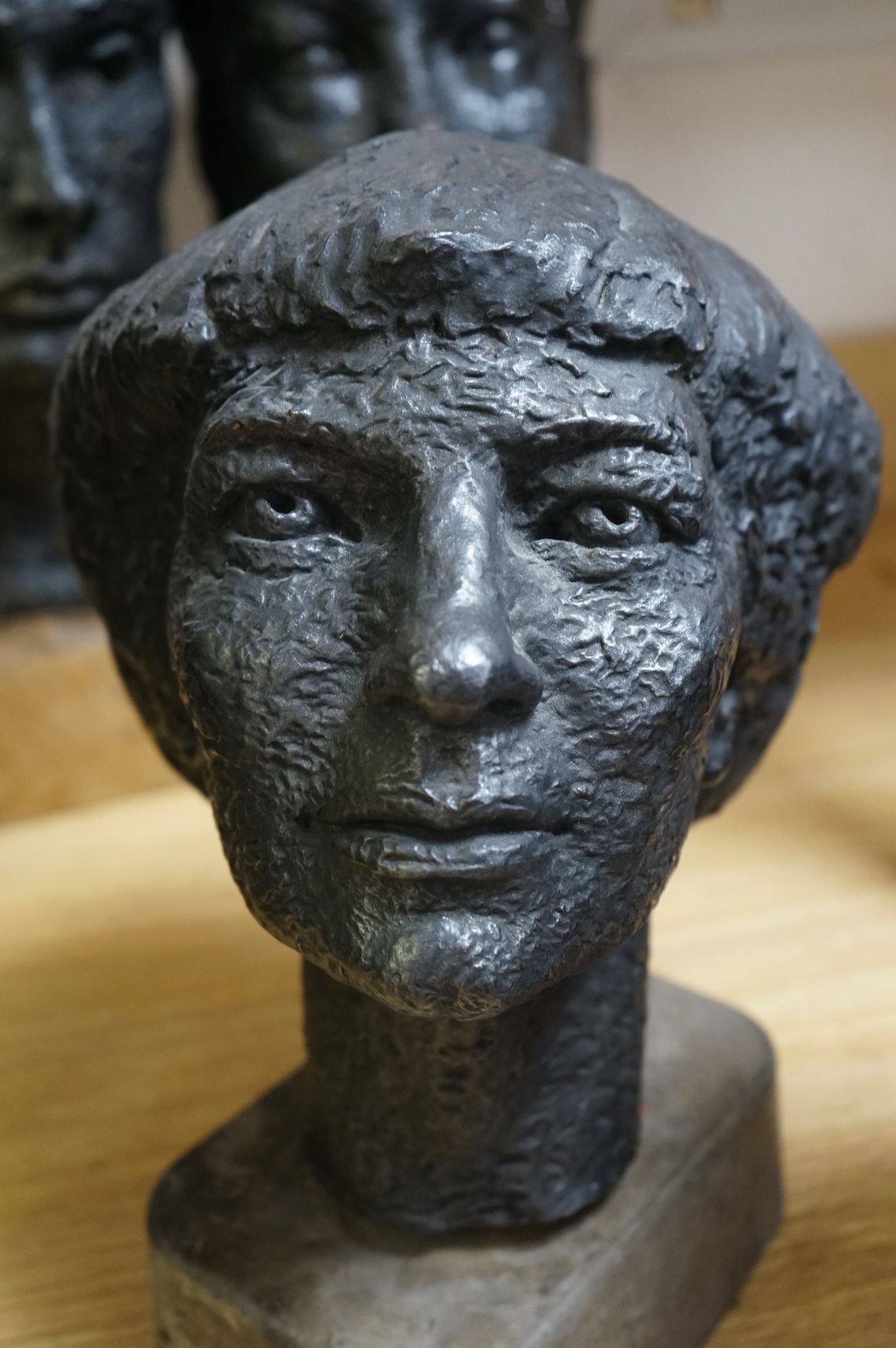 Six black painted composition heads, by Hazel Armour, tallest 49cm